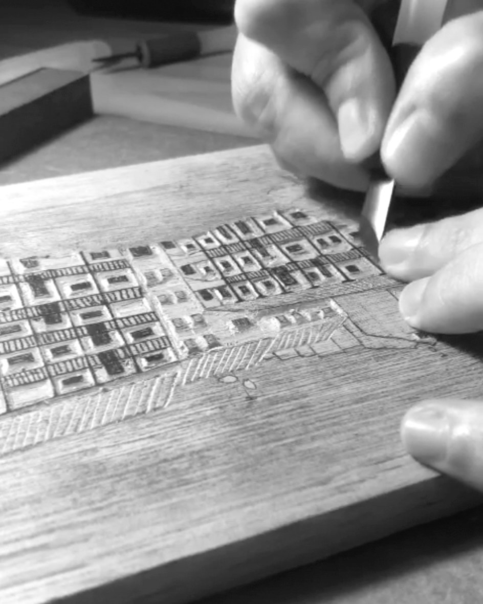 Mãos entalhando uma matriz de madeira com goiva em aula de xilogravura no Centro de Artes da Vila Telebrasília